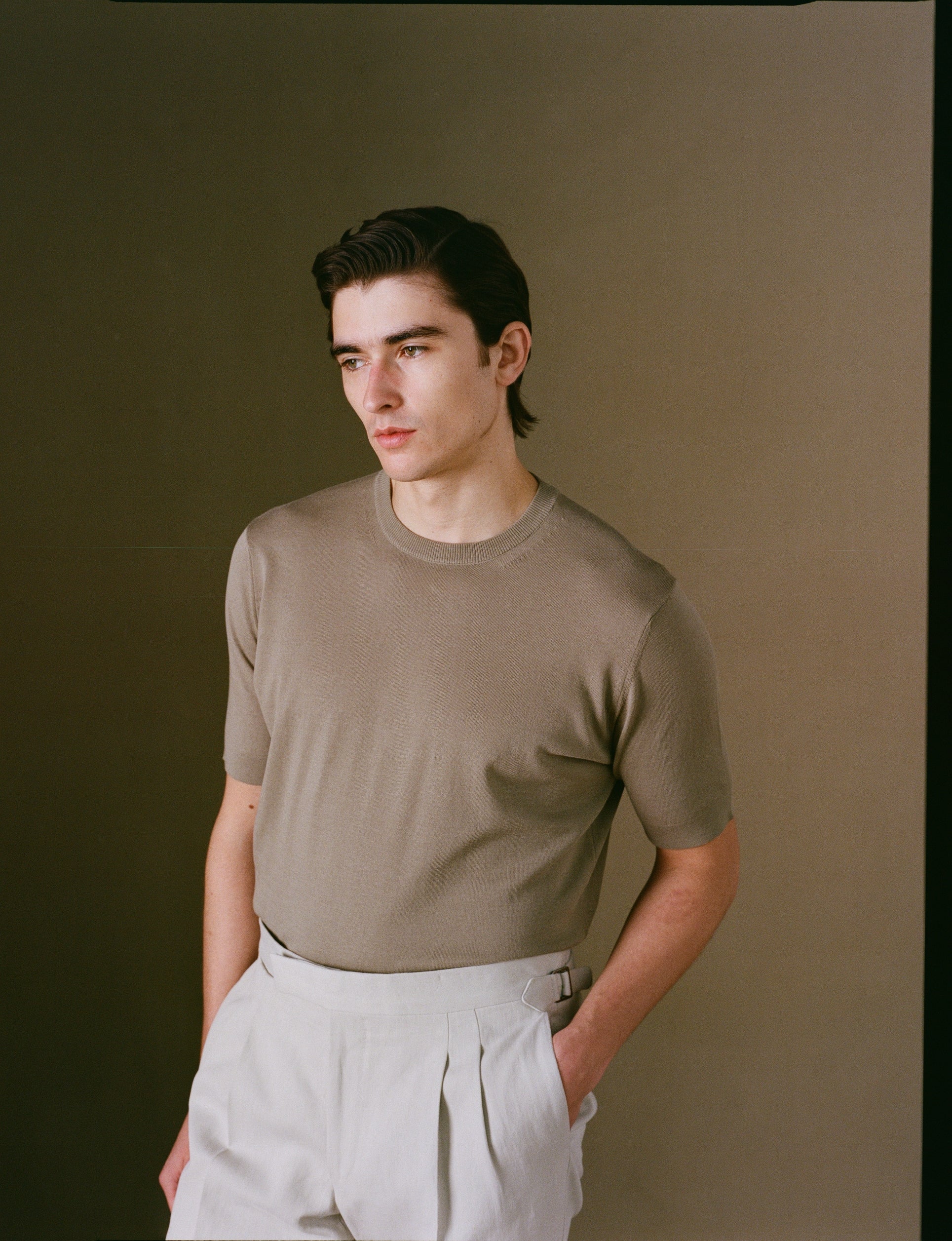 Person wearing a beige shirt against a plain background
