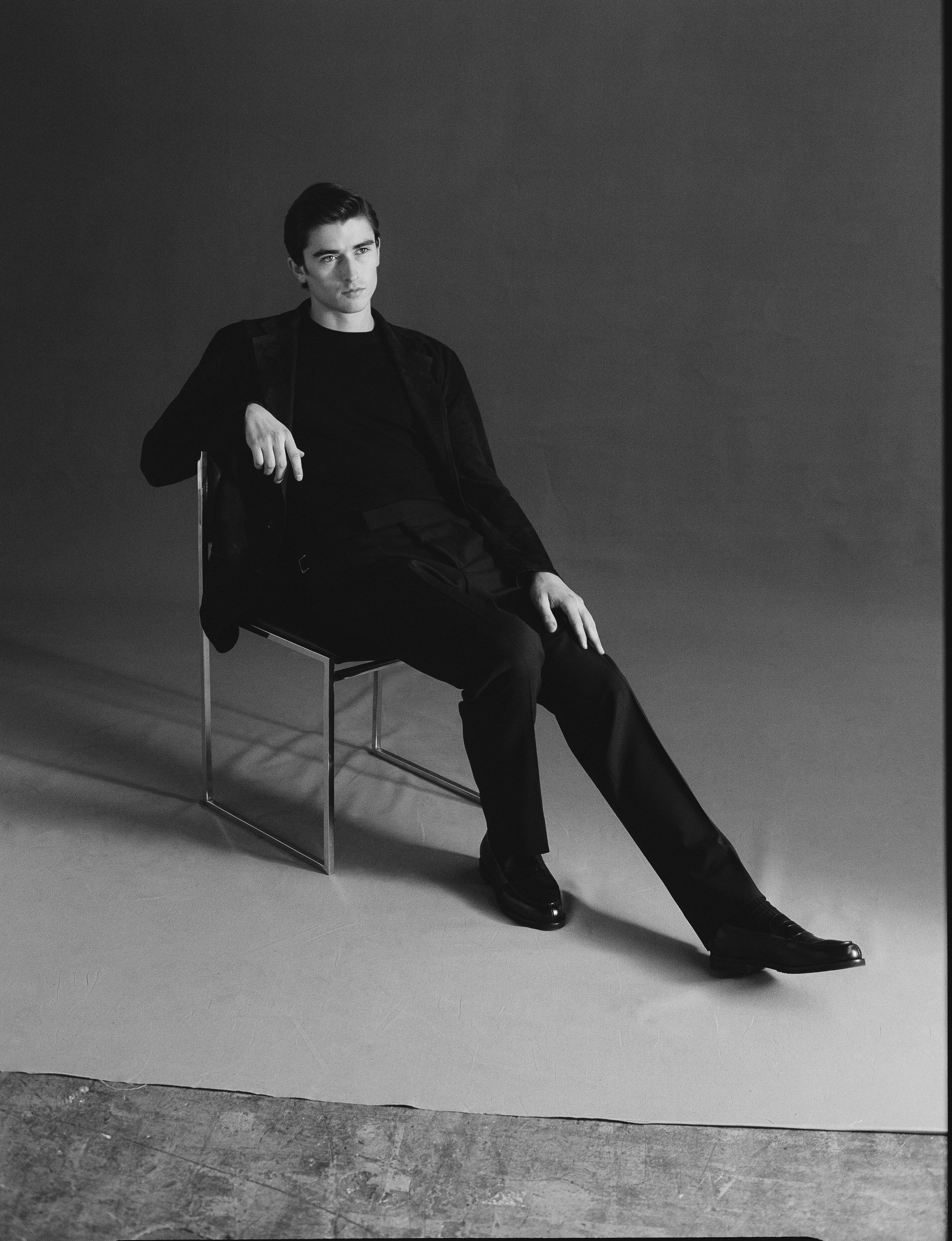 Man sitting on a chair against a plain background