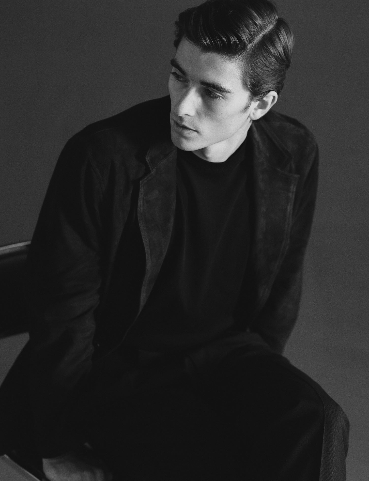 Black and white portrait of a person wearing a dark coat and shirt.