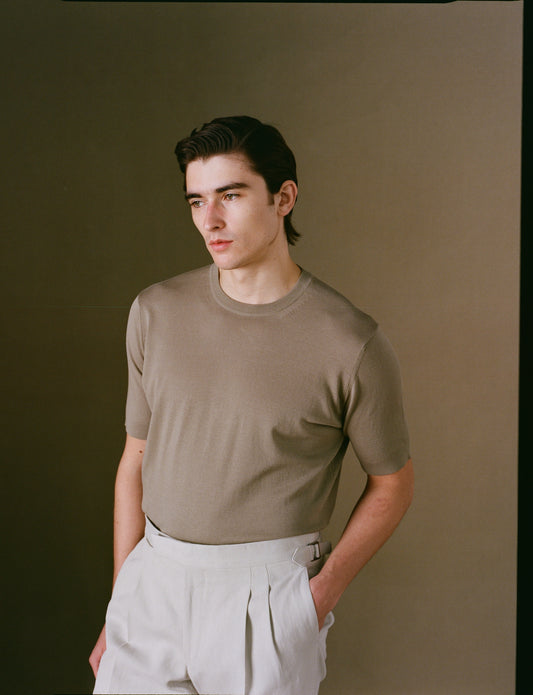 Person wearing a beige shirt against a plain background