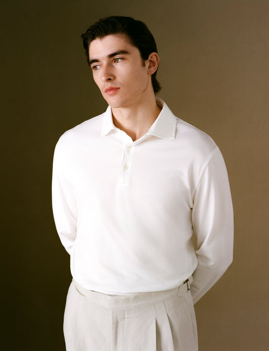 Man wearing a white long-sleeve shirt against a brown background