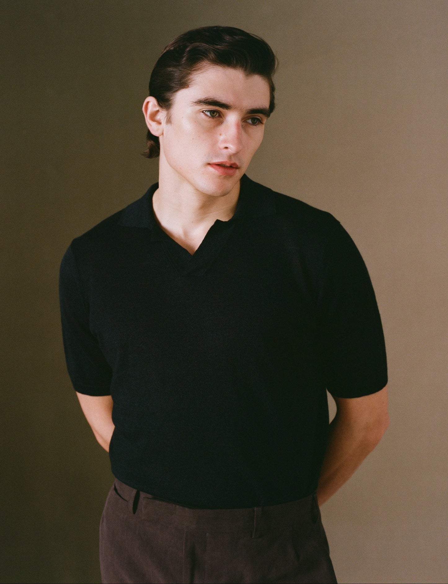 Person wearing a black shirt against a plain background