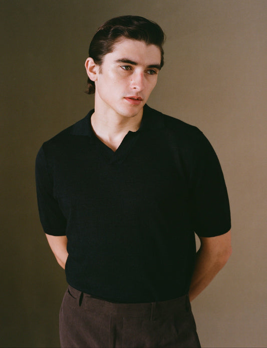 Person wearing a black shirt against a plain background